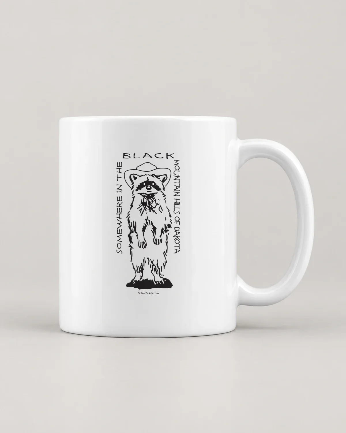 Mountain Raccoon tee on a ceramic mug